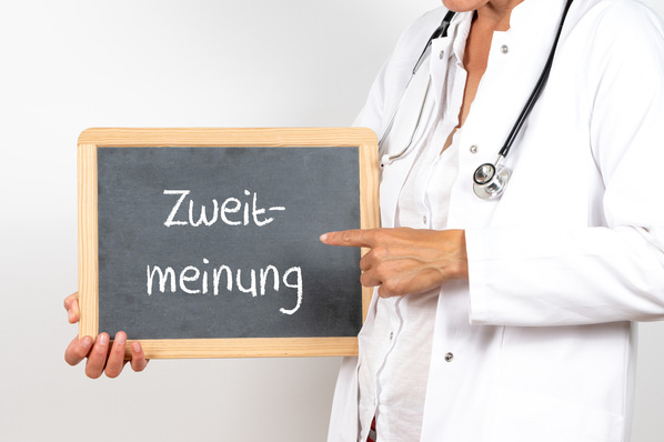 Alt-Text: „Ein Arzt mit Stethoskop erläutert medizinische Konzepte am Whiteboard, das den Begriff ‚Zweitmeinung‘ enthält, im Kontext der Begutachtung und Rechtsprechung. - © HNFOTO - stock.adobe.com