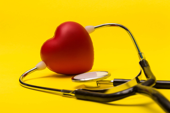 Ein rotes Herz und ein Stethoskop auf einem leuchtend gelben Hintergrund. - © Ben Gingell - stock.adobe.com