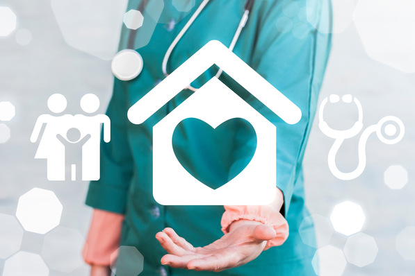 Eine Mitarbeiterin des Gesundheitswesens hält eine Hand vor, auf der Symbole für Gesundheit und Familie abgebildet sind. - © wladimir1804 - stock.adobe.com